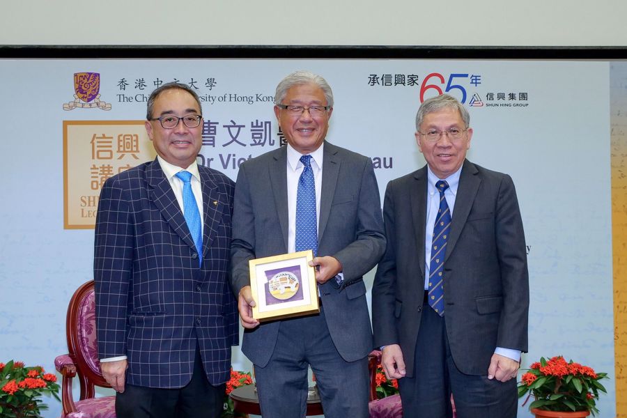 信興集團主席兼行政總裁蒙德揚博士(左)及中大副校長陳偉儀教授(右)致送紀念品予曹文凱醫生。