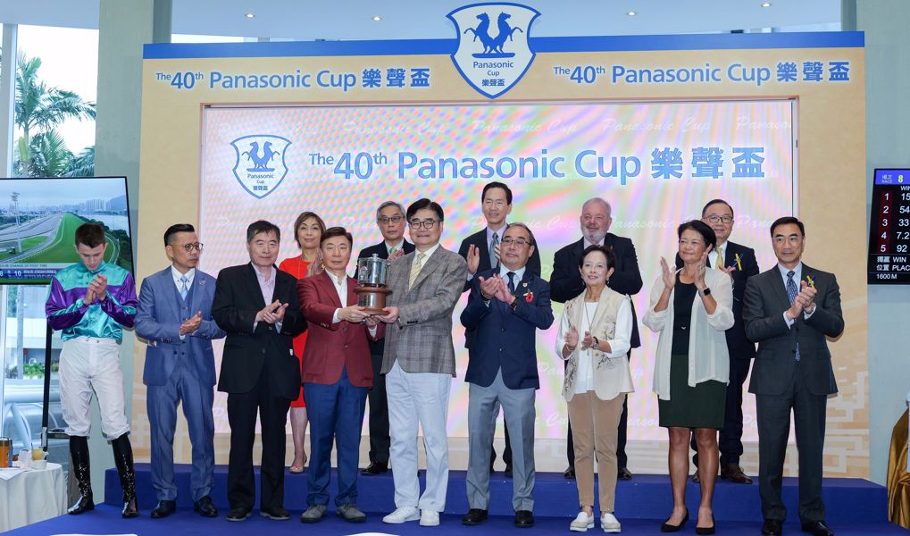 Panasonic Holdings Corporation 集團副總裁本間哲朗先生（右）將「樂聲盃」獎盃頒予「美好世界」的馬主蘇凱榮（左）。