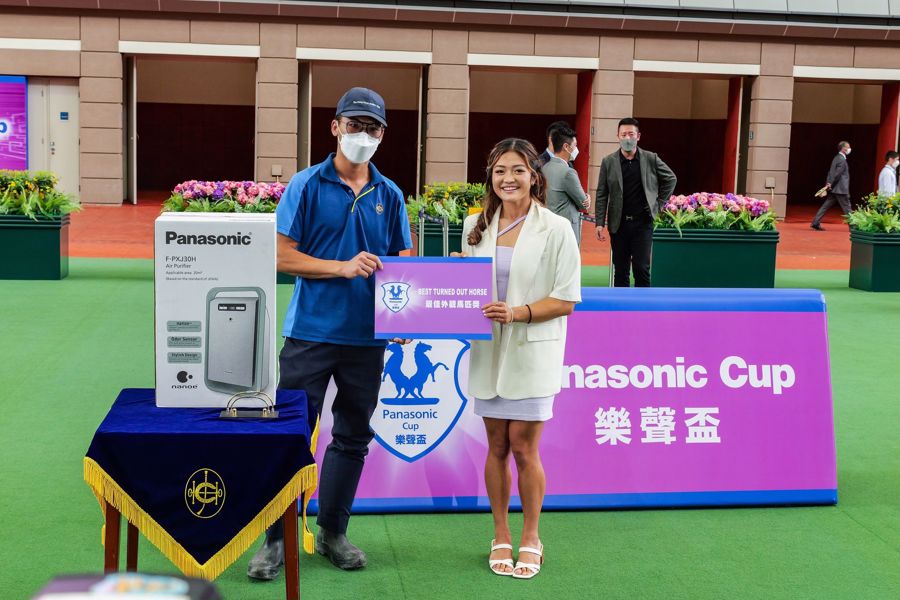 信興電器貿易有限公司市務統籌高級經理蒙淑美小姐（右）將最佳外觀馬匹獎頒發予負責照料「健康愉快」的馬房助理。
